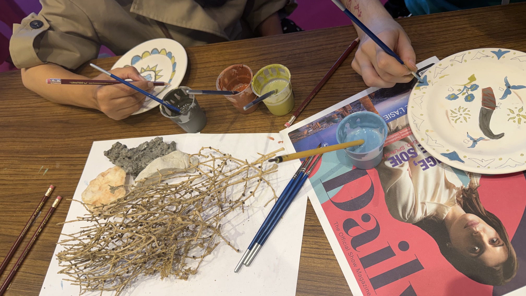 Atelier de peinture sur céramique avec pinceaux, couleurs et pièces décorées sur le stand de l’Ouzbékistan à l’IFTM Top Resa 2026.